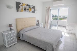 a bedroom with a bed and a view of a balcony at Debimar Apartamentos in Albufeira