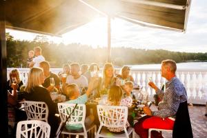 un grupo de personas sentadas alrededor de una mesa en una cubierta en Västervik Resort, en Västervik