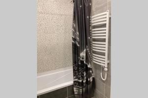 a bathroom with a shower with a black and white towel at Lazdyneliu Apartamentai in Vilnius