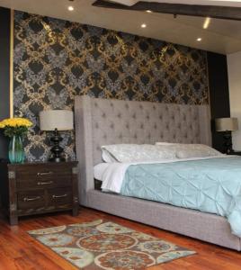 a bedroom with a bed with a headboard and a table at Hotel Azul de la Plaza in Cuenca