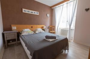 een slaapkamer met een bed, een tafel en een raam bij La Belle Arverne in Albepierre-Bredons