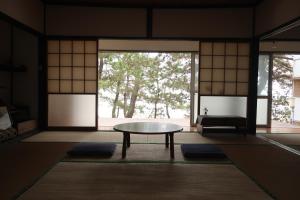 a room with a table in front of a window at 奈多みどり荘 Nada Beach House in Kitsuki