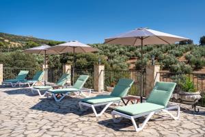 a row of chairs and umbrellas on a patio at Hacienda la buena vida B&B en appartementen casita almendas in La Carrera de la Viña