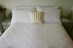 a bed with white sheets and pillows at Castle Lodge in Sheriff Hutton