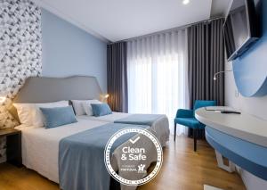ファティマにあるHotel Rosa Mística by Umbralのベッドとデスクが備わる清潔で安全なホテルルームです。