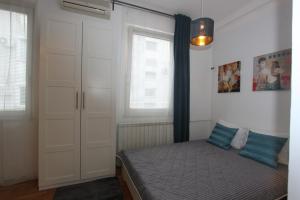 una camera con un letto e due finestre di Apartment Bg Arena a Belgrado