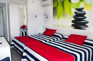 a bedroom with two beds with red and black pillows at Hotel Europa Splash & Spa in Malgrat de Mar