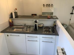 uma pequena cozinha com um lavatório e um fogão em Le Temps d'une Pause em Teyran