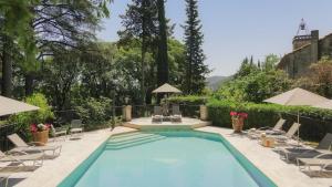 uma piscina com cadeiras e uma mesa em Chateau de Varenne em Sauveterre