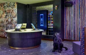 
a dog sitting in front of a computer desk at NYX Hotel London Holborn by Leonardo Hotels in London
