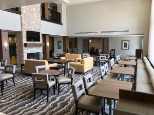 a restaurant with tables and chairs and a fireplace at Staybridge Suites Irvine - John Wayne Airport by IHG in Irvine