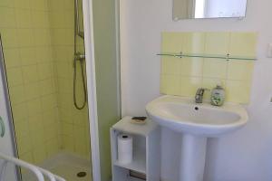 a white bathroom with a sink and a shower at Studio Option face à la mer in Agon Coutainville +18 photos