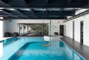 a swimming pool with blue water in a building at Villa della Giovanna by VacaVilla in Buia