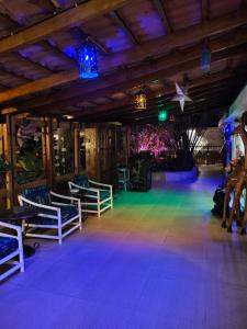 ein Zimmer mit Stühlen und einer Bühne mit lila Lichtern in der Unterkunft Hotel Tilapia in Mwanza
