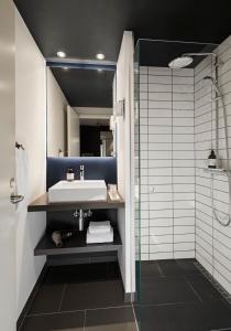 een badkamer met een wastafel en een glazen douche bij Comwell Kongebrogaarden in Middelfart