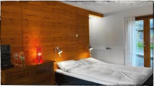 a bedroom with a bed and a wooden wall at Bergvegen Guesthouse Aalesund in Ålesund