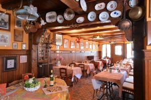 a restaurant with tables and chairs and plates on the wall at Chez Madeleine in Châtenois
