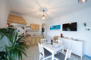 a kitchen with a table and a white table and chairs at Sea Side Solandra in Praiano