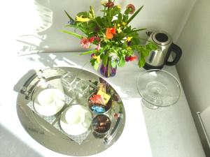a table with a glass plate with candles and a vase of flowers at Haus Loretz in Lasa