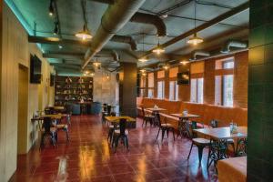 a restaurant with tables and chairs in a room at Старый Томас in Kogalym