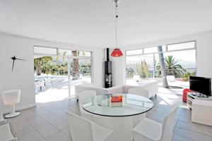 a living room with a glass table and white chairs at Casa pequena in La Orotava