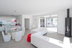 a living room with white furniture and a kitchen at Casa pequena in La Orotava