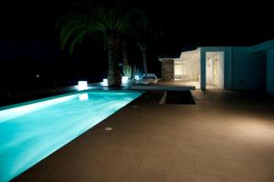 a swimming pool at night with a palm tree at Casa pequena in La Orotava