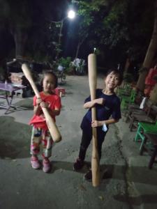 dos niños pequeños parados junto a los bates de béisbol en Sky Gift Traditional Farm B&B, en Dongshi