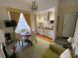 ein Wohnzimmer mit einem Esstisch und einer Küche in der Unterkunft Pier View Self Catering Luxury Apartments in Southend-on-Sea