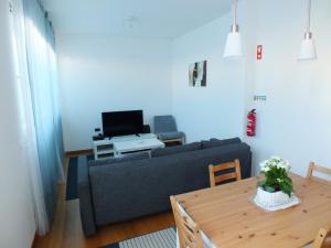 a living room with a couch and a table at Sun with Style in Figueira da Foz