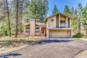 a house with a garage in the woods at Sundial on Deck in Sunriver