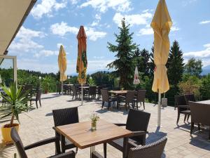 a patio with tables and chairs and umbrellas at Gasthof Thomann in Velden am Wörthersee