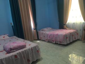 a room with three beds with pink sheets at Cikgu CTZ Homestay (B) in Kampong Kubang Bemban