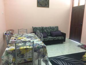ein Wohnzimmer mit einem Bett und einem Sofa in der Unterkunft Cikgu CTZ Homestay (B) in Kampong Kubang Bemban
