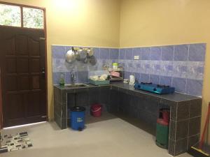 eine Küche mit einer Theke, einem Waschbecken und einer Tür in der Unterkunft Cikgu CTZ Homestay (B) in Kampong Kubang Bemban