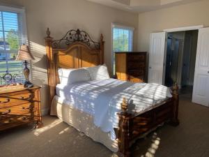 um quarto com uma grande cama de madeira e uma cómoda em Cottages and Suites at River Landing em Wallace