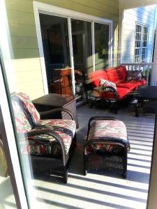 una veranda con sedie in vimini e un divano in una casa di Cottages and Suites at River Landing a Wallace