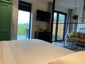 a bedroom with a white bed and a large window at Guesthouse Scherp in Middelburg