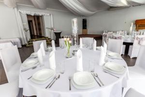 a white table with white plates and silverware on it at U Aktorów - Pokoje Gościnne in Elblag
