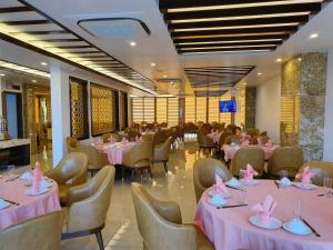 a restaurant with pink tables and chairs with pink napkins at Golden Palm HaLong Hotel in Ha Long