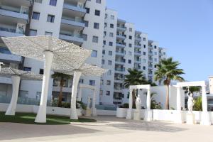 duży biały budynek z palmami przed nim w obiekcie Ocean Garden Suite 612 w Adeje