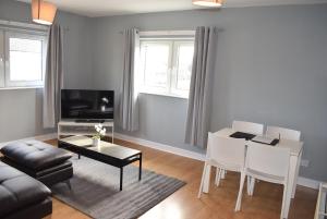 sala de estar con sofá y mesa en Kelpies Serviced Apartments- Campbell, en Pumpherston