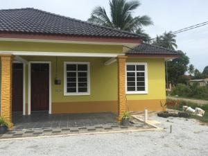 a small house with a yellow at Cikgu CTZ Homestay (C) in Kampong Kubang Bemban