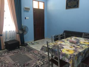 - une chambre avec un lit et un mur bleu dans l'établissement Cikgu CTZ Homestay (C), à Kampong Kubang Bemban