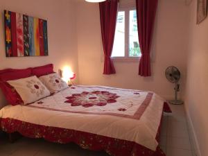 une chambre avec un lit avec des rideaux rouges et une fenêtre dans l'établissement Appartement T3 Climatisé entre mer et centre Nice, à Nice