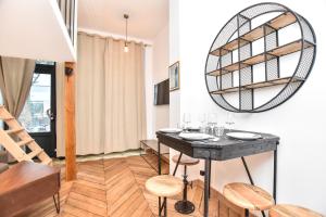 een eetkamer met een tafel en stoelen en een spiegel bij CMG - VIGNOLES in Parijs
