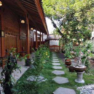 un jardín con una pasarela frente a un edificio en Dapur ethnic guesthouse, en Bantul