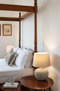 a bedroom with a bed with a table with a lamp at Amera Luxury Villas in Peyia