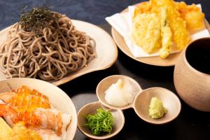 a group of plates of food with noodles and vegetables at Hotel Asia Center of Japan in Tokyo