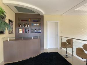 a lobby with a bar with a couch and a chair at Casa de Campo Alto Padrao in Piracaia